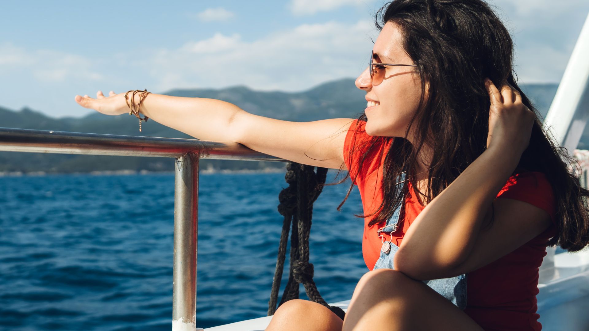 A passenger on a tour boat is enjoying the ocean views